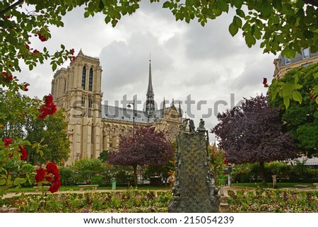 View of the Cathedral of Notre Dame de Paris through the arch of roses in the old city park