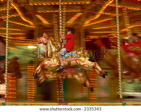 A boy riding on a merry-go-round - motion blur