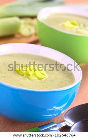 Two bowls of fresh homemade creamy leek soup (Selective Focus, Focus on the leek rings on the top of the soup)