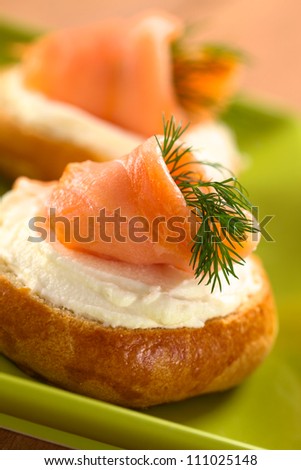 Smoked salmon and cream cheese canapes garnished with dill (Selective Focus, Focus on the front of the salmon)