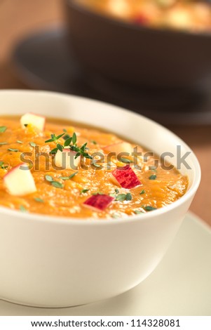 Two bowls of fresh homemade sweet potato and apple soup with thyme (Selective Focus, Focus in the middle of the soup)
