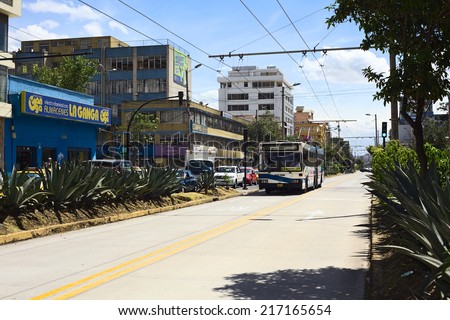 QUITO, ECUADOR - AUGUST 4, 2014: Trole C1 trolleybus of the bus rapid transit system on 10 de Agosto Avenue with the stop Santa Clara in the back on August 4, 2014 in Quito, Ecuador