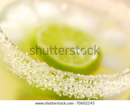 The sugar rim of a glass filled with fresh lemonade with lime slices and ice cubes (Very Shallow Depth of Field, Focus on small part of the sugar rim)