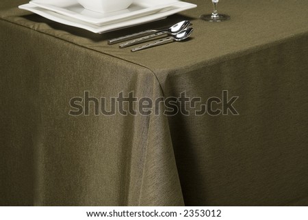 table setting showing linen table cloth, dishes and silverware