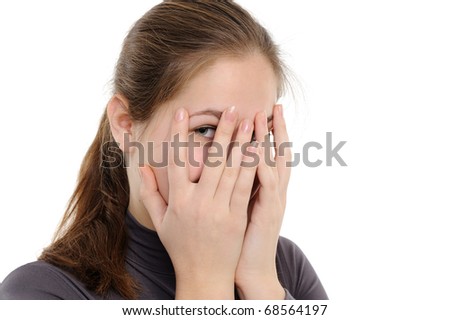 Yong woman hide her face through fingers, on a white background