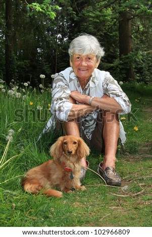 Senior lady outside with her dachshund dog.