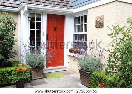 Charming colorful front door entrance with blooming lavender in containers.