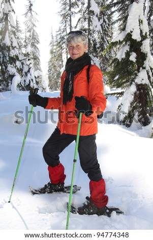Seventy year old lady having fun snowshoeing on Mount Seymour, Vancouver, Canada.