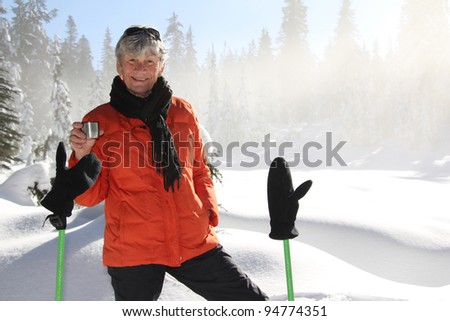 Seventy year old lady having fun snowshoeing on Mount Seymour