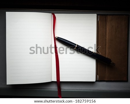Notebook with a pen on the side
