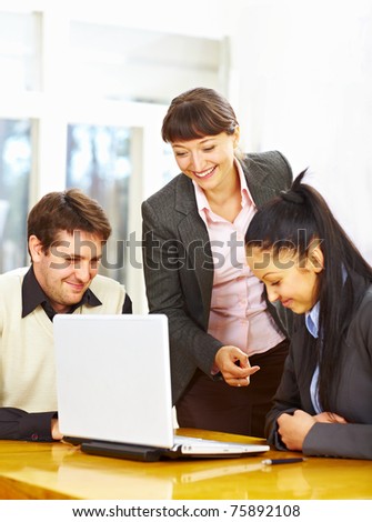 Business people sitting at the table and looking at laptop