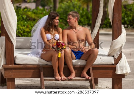husband and wife relaxing on sunbeds at the beach.