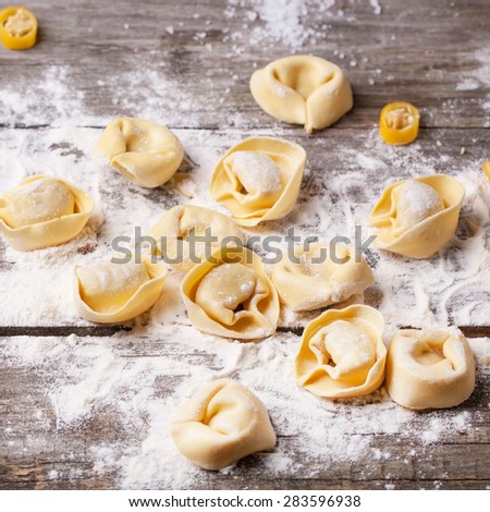 Homemade pasta ravioli over wooden table with flour