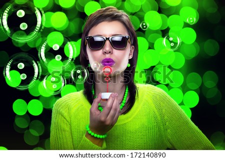 Portrait of young woman blowing soap bubbles. Relaxed woman. Fun party with bubbles.