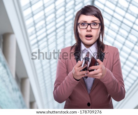 Beautiful business woman with empty purse. Business decisions. Office workers. Bemused girl in glasses. Beautiful light background