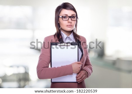 Beautiful business woman with a folder in hands. Business decisions. Office workers. Friendly smiling girl. Beautiful light background