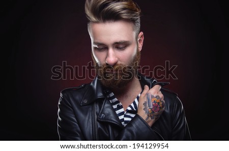 Handsome stylish young man. Brutal man with a beard and tattoo