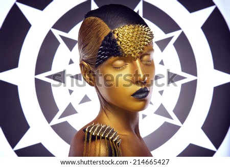 Beautiful young woman with gold makeup. Face art
