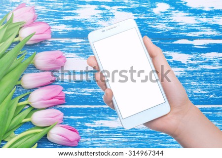 Mobile phone on the background board with flowers. Mobile technology. Mobile photo. Insert text