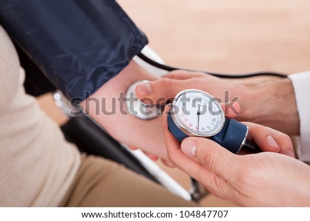 Doctor checking blood pressure of a woman. Close-up shot