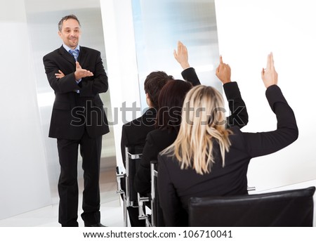 Group of successful business people at the lecture asking questions