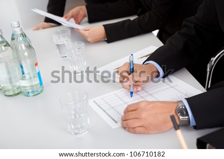 Group of business people taking notes at the meeting