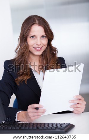 Smiling businesswoman working at her computer in the office
