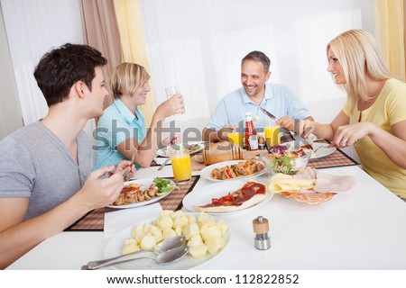 Attractive family enjoying a healthy meal together seated around the table