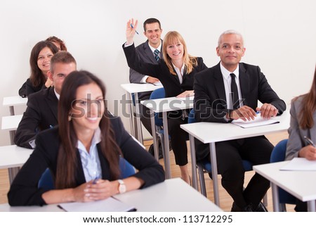 Businesswoman Raising Her Hand In Meeting To Ask Question