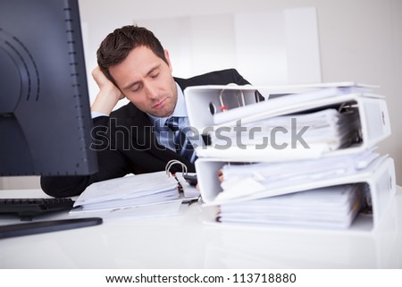 Bored Businessman Overwhelmed By Paperwork In The Office