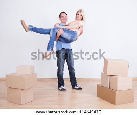 Portrait Of Husband Holding Wife In New Home, Indoors