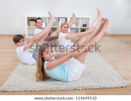 Family Doing Stretching Exercises Laying On The Carpet At Home