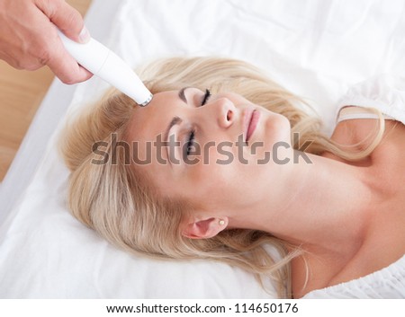 Profile View Of Happy Young Woman During Cosmetic Treatment, Indoors