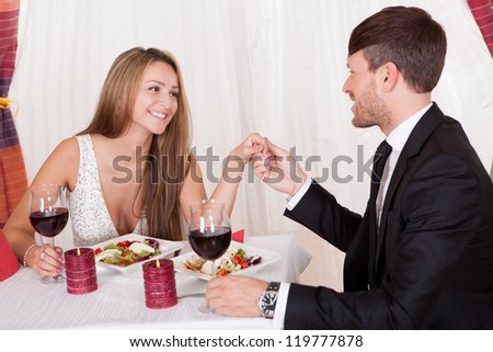Attractive loving couple enjoying a romantic meal by candlelight at a stylish restaurant as they celebrate Valentines or their anniversary