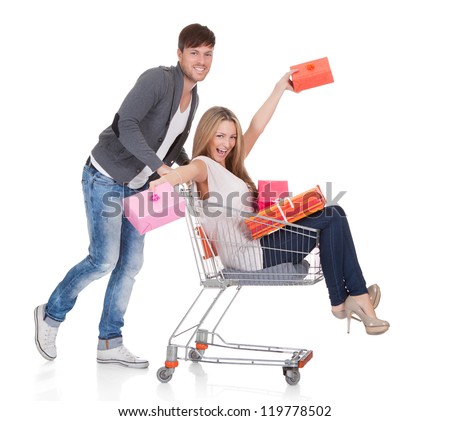 Woman carried by push cart held by man.