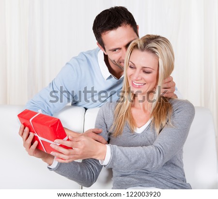 Man giving his wife a surprise gift at home