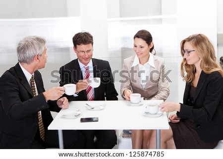 Business colleagues relaxing over coffee or having an impromptu meeting in the cafeteria