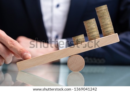 Close-up Of A Businessperson Balancing Increasing Stacked Coins With Finger On Seesaw Stock foto © 