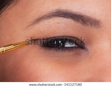 Young Woman Apply Make-up Over White Background