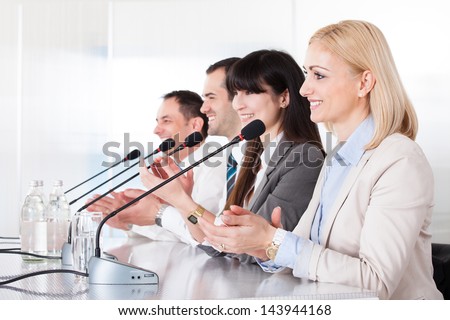 Business People Speaking In Microphone In Office