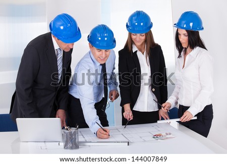 Group Of Architects Working On Project In Office