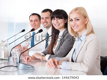 Business People Speaking In Microphone In Office