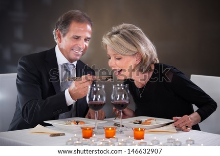Romantic Mature Couple Having Dinner At Restaurant
