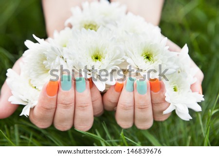 Close-up Of Woman\'s Hands With Nail Varnish Holding Flower