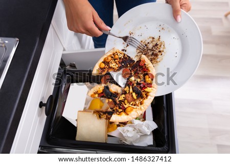 Close-up Of A Person Throwing Pepperoni Pizza On Plate In Dustbin Stockfoto © 