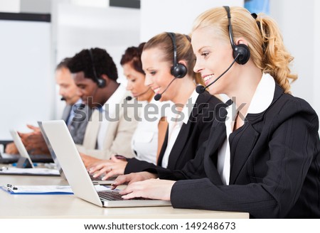 Happy Co-workers Wearing Headsets Working In Call Center