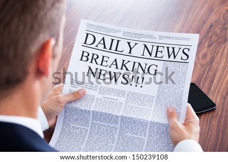 Young Businessman Reading Breaking News On Newspaper