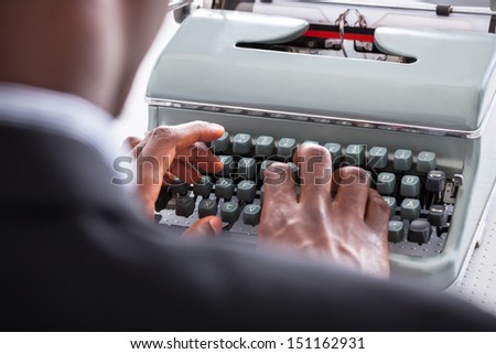 Portrait Of Happy Business Man Typing On Typewriter