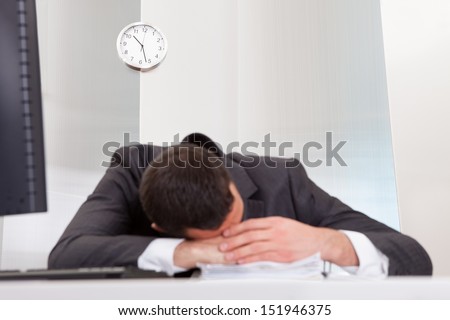 Successful businessman sleeping at desk it the office
