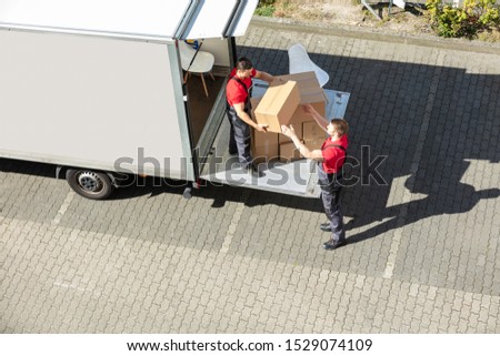An Overhead View Of A Male Movers Unloading The Cardboard Boxes Form Truck On Street Photo stock © 